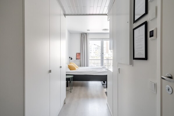 Une chambre d’hôtel moderne, équipée d’un lit, d’un bureau et offrant une vue sur la ville grâce à de grandes fenêtres.
