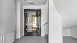 A modern hallway with a black door labeled "A2," a radiator, and a black carpet. - Hiisi Homes Turku Fleminginkatu (Turku)