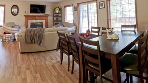 A living room with a fireplace, a TV, and a dining area with a table and chairs. - Two Master Family Home / Easy to Access Year-Round / Nearby Trails (South Lake Tahoe)