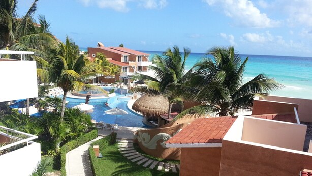 A resort with a swimming pool, palm trees, and a view of the ocean. - Beach Resort, Playa Del Carmen, Mexico, Spectacular View! 333S (Playa del Carmen, QRO)