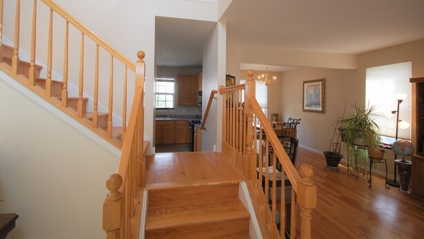 A spacious living area with a wooden staircase leading to a second floor. - Spacious and comfortable 5 bedroom, 2 1/2 bath two miles from down town Geneva (Geneva)