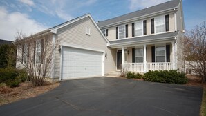 A two-story house with a garage, a front porch, and a driveway. - Spacious and comfortable 5 bedroom, 2 1/2 bath two miles from down town Geneva (Geneva)
