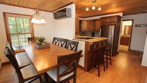 Una cocina amplia con armarios de madera, un refrigerador de acero inoxidable y una isla grande con taburetes.