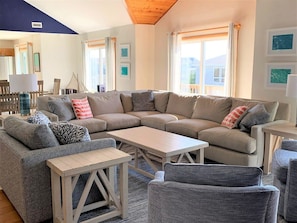 A modern living room with a sectional sofa, a coffee table, and patterned chairs.
