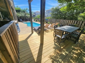 A wooden deck with a pool, lounge chairs, and a table. - 5BR Corolla Light retreat with pool, hot tub & beach access. CL-134 (Corolla)
