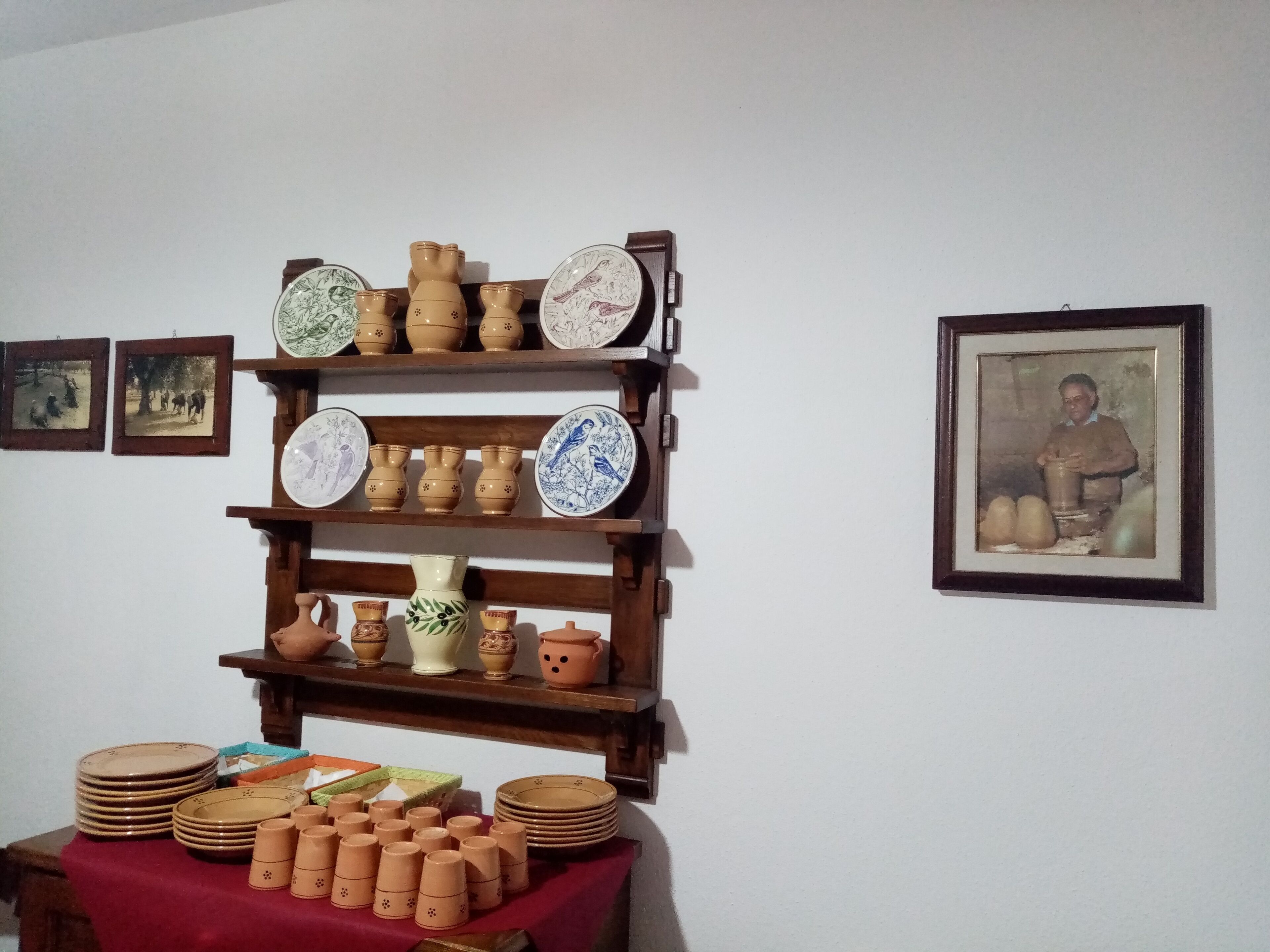 A display of pottery and ceramics on shelves and a table.