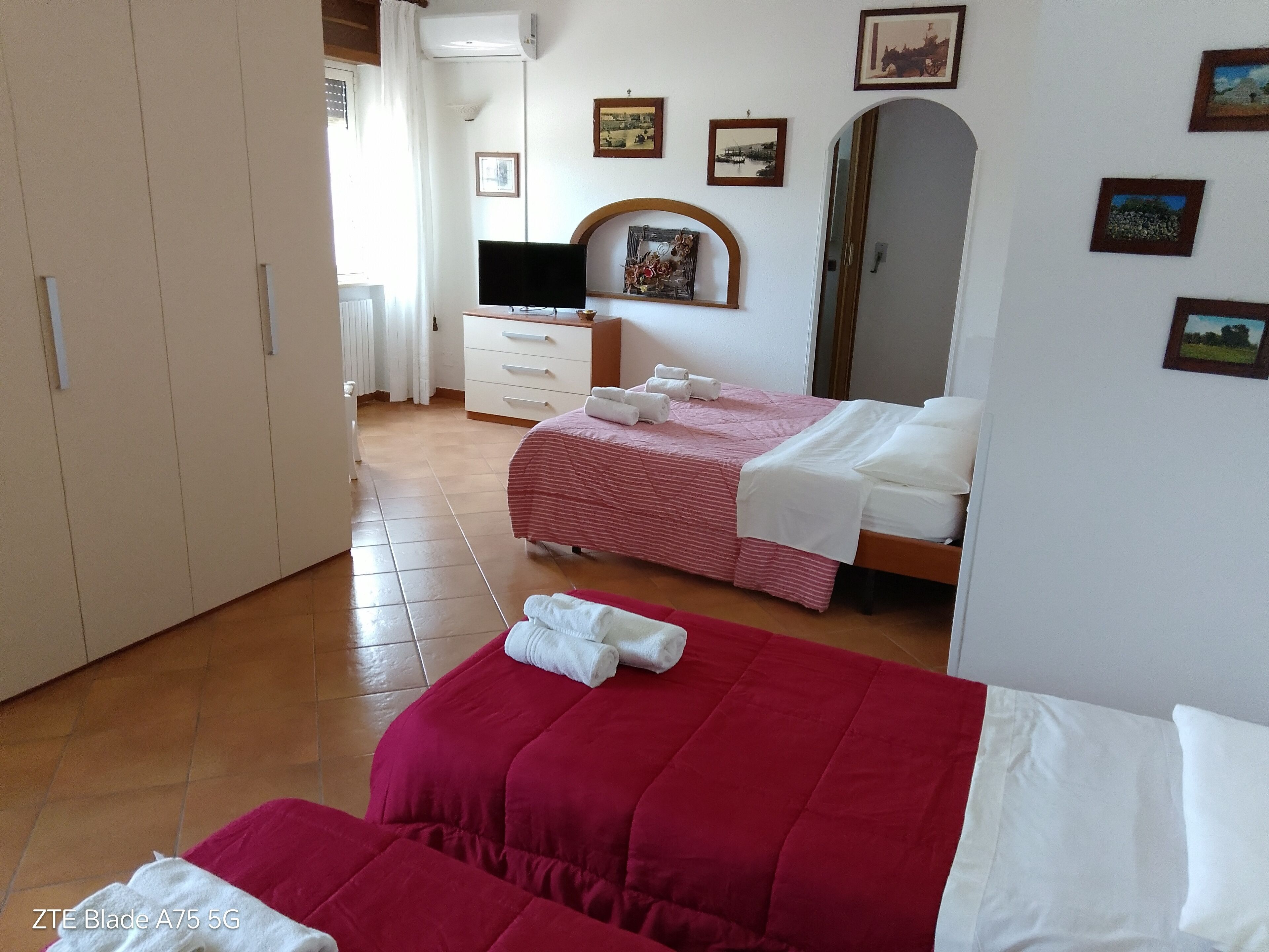 Habitación de hotel con dos camas, televisión, armario y baño.