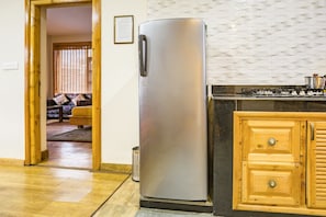 Una cocina con un refrigerador de acero inoxidable, armarios de madera y un salpicadero decorativo.