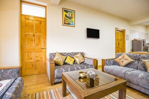 A living room with two sofas, a coffee table, and a TV. - GuestHouser 1 BR Cottage 4e68 (Manali)