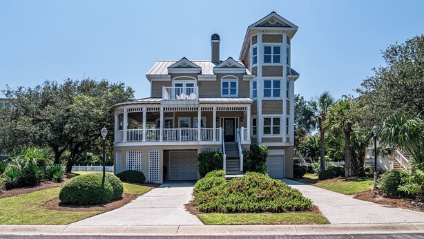 A two-story house with a wrap-around porch, a tower-like structure on the right, and a garage. - Legasea DeBordieu Home LegaSea Spectacular porches Close to Beach (Georgetown)