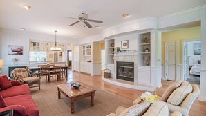A spacious living room with a fireplace, a dining area, and a kitchen. - Legasea DeBordieu Home LegaSea Spectacular porches Close to Beach (Georgetown)