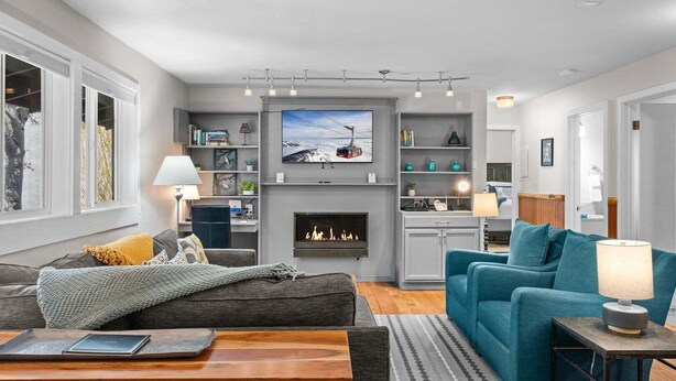 A modern living room with a fireplace, a television, and a cozy seating area. - RMR: Gros Ventre A5 Condo in Teton Village (Teton Village)