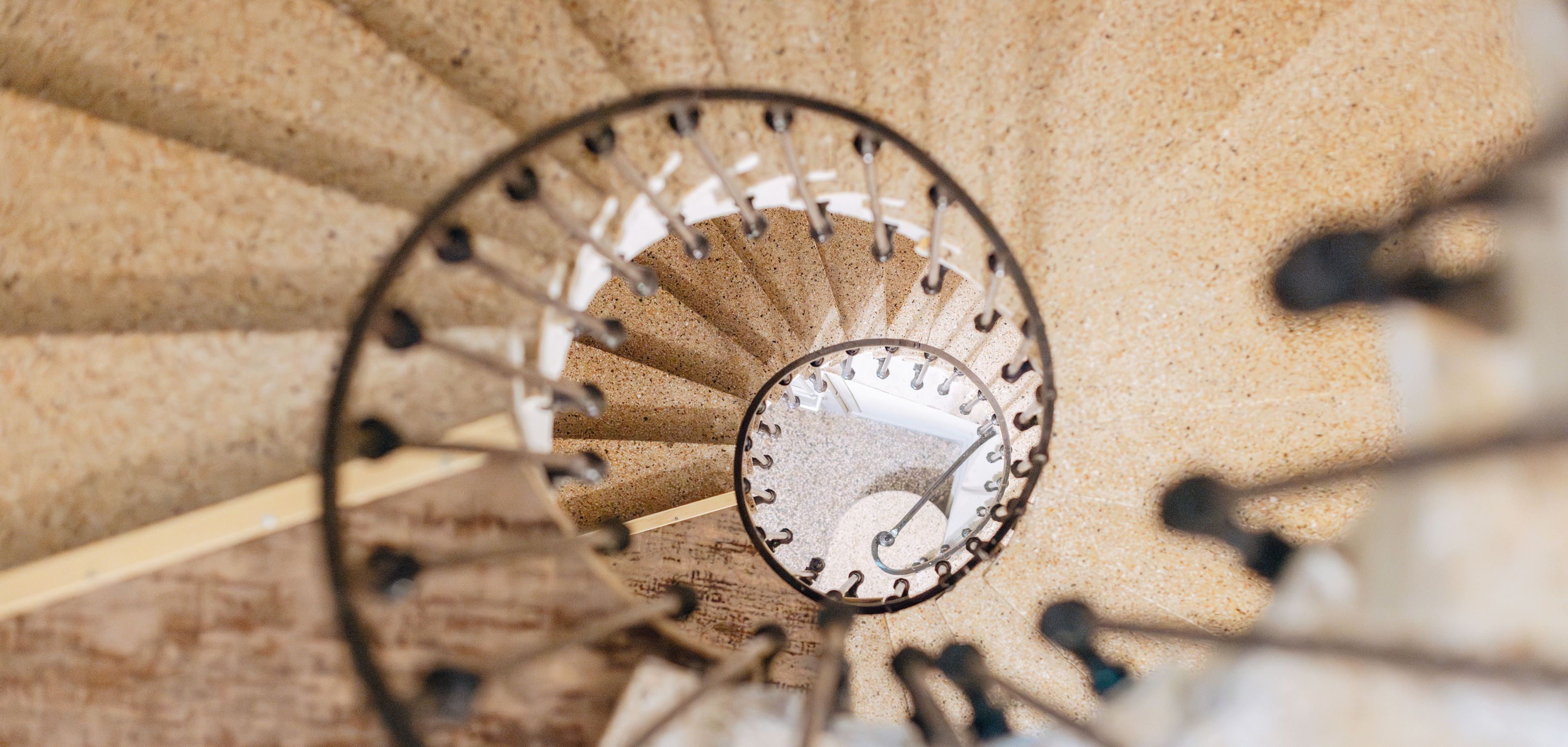 A spiral staircase with a clock, indicating a 3-floor walk-up hotel without an elevator.