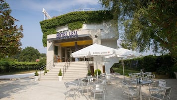 A hotel named "HOTEL LEAL" with outdoor seating and a staircase leading to the entrance.