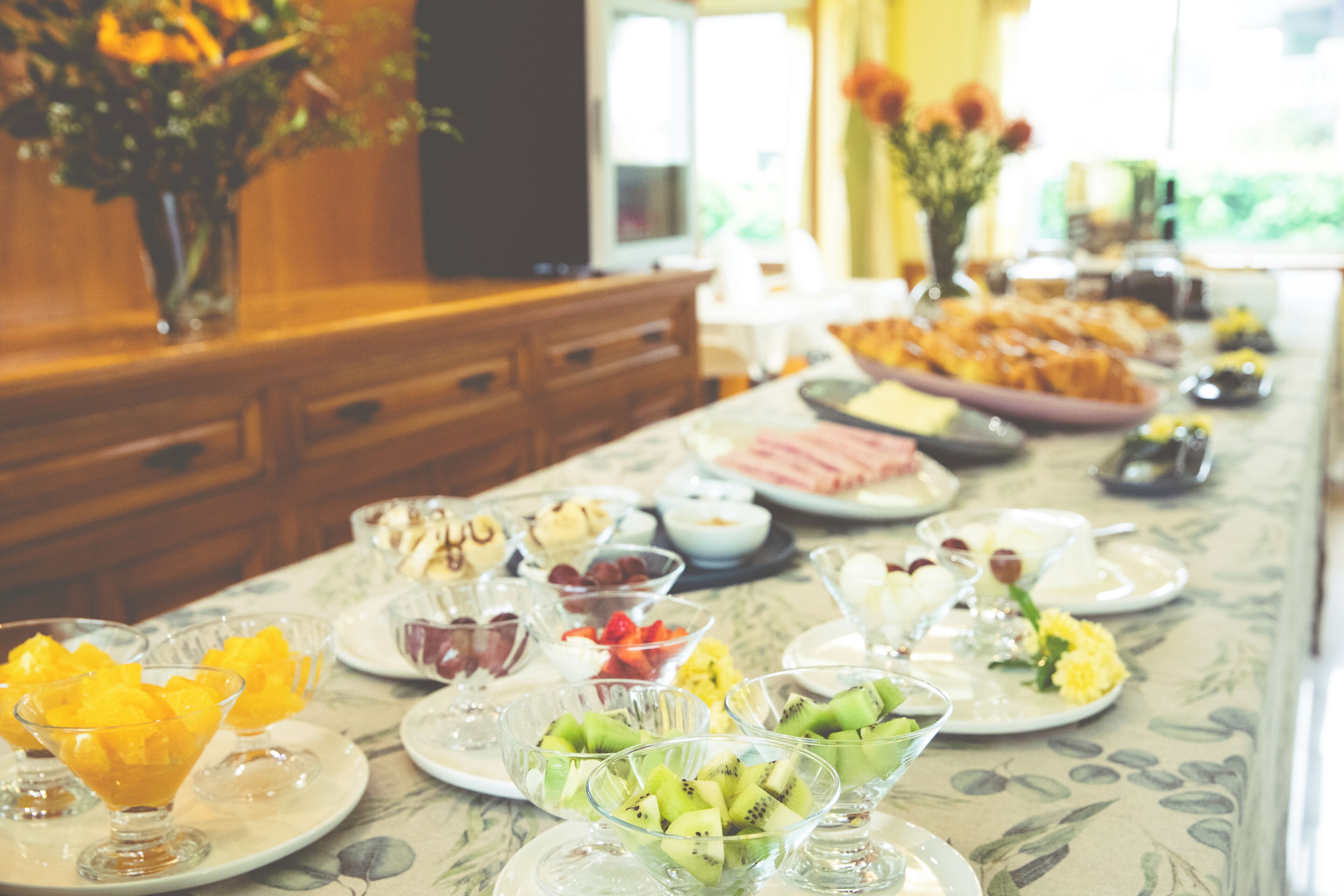 Una mesa de buffet con diversos alimentos y un florero con flores.