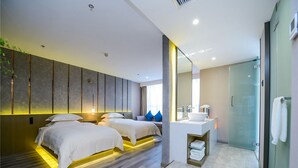 A modern hotel room with a large bed, a separate seating area, a bathroom with a glass shower, and a minimalist design. - 9H Hotel (Chongqing)