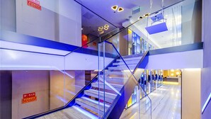 Un interior moderno con una escalera de cristal y un suelo pulido.