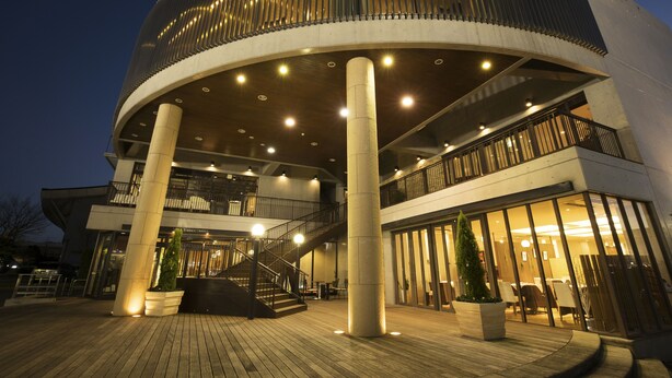 A modern building with a circular central section, multiple floors, and a prominent staircase. - Villa Terrace Omura Hotels & Resorts (Omura)