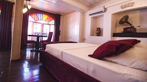 A hotel room with a large bed, a cat tree, a desk, and a window with curtains. - Lusin Butik Hotel (Ayvalik)