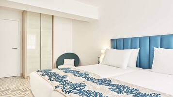 Une chambre d’hôtel avec un lit, une chaise et une table de chevet avec une lampe.
