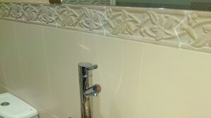 A bathroom with a marble sink, a toilet, and a wooden vanity. - La Cerca de Doña Jimena (Ibeas de Juarros)