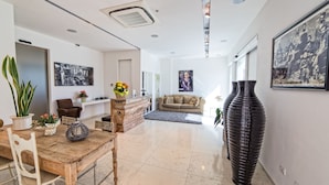 A modern living room with a wooden coffee table, a beige sofa, and a large black vase. - Hotel Radice (Civitanova Marche)