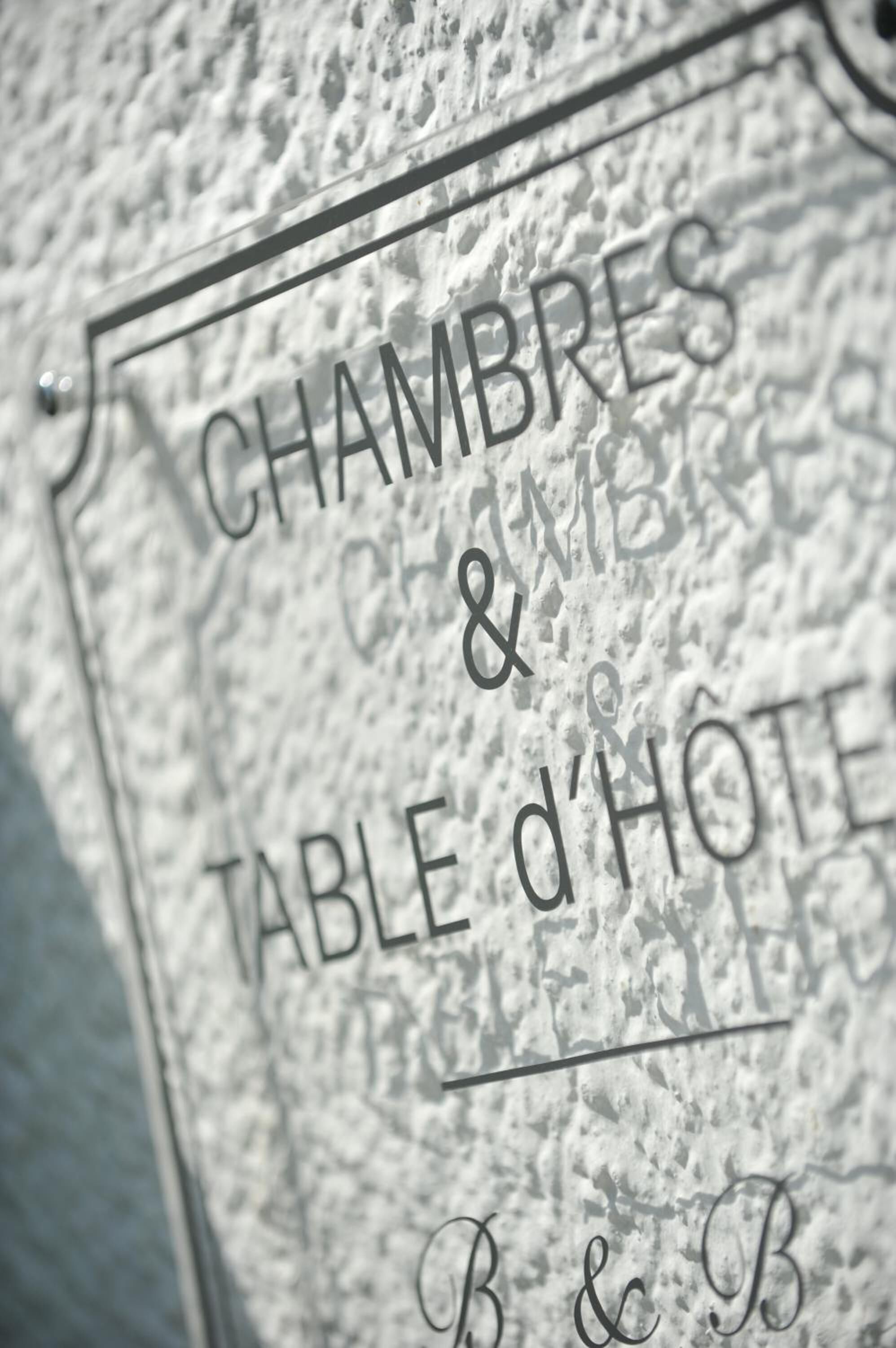 A stone plaque with the inscription 'CHAMBRES & TABLE d'HOTE' and 'B&B' indicating a bed and breakfast establishment.