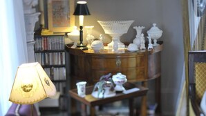 Una sala de estar acogedora con una mesa de centro de madera, una lámpara, una estantería y objetos decorativos.