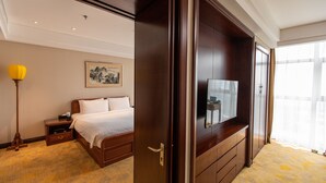 A hotel room with a bed, bedside table, lamp, artwork, and a large wardrobe. - Beijing Broadcasting Tower Hotel (Beijing)