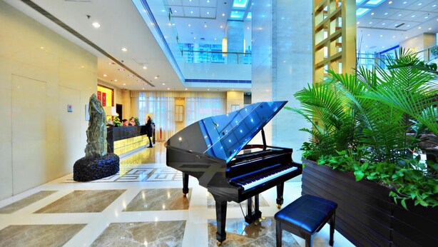 A grand piano in a spacious lobby with a high ceiling and a modern design. - Beijing Broadcasting Tower Hotel (Beijing)