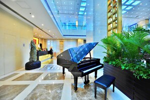 A grand piano in a spacious lobby with a high ceiling and a modern design. - Beijing Broadcasting Tower Hotel (Beijing)
