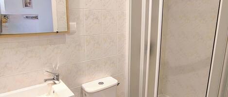 A bathroom with a toilet, sink, and shower.