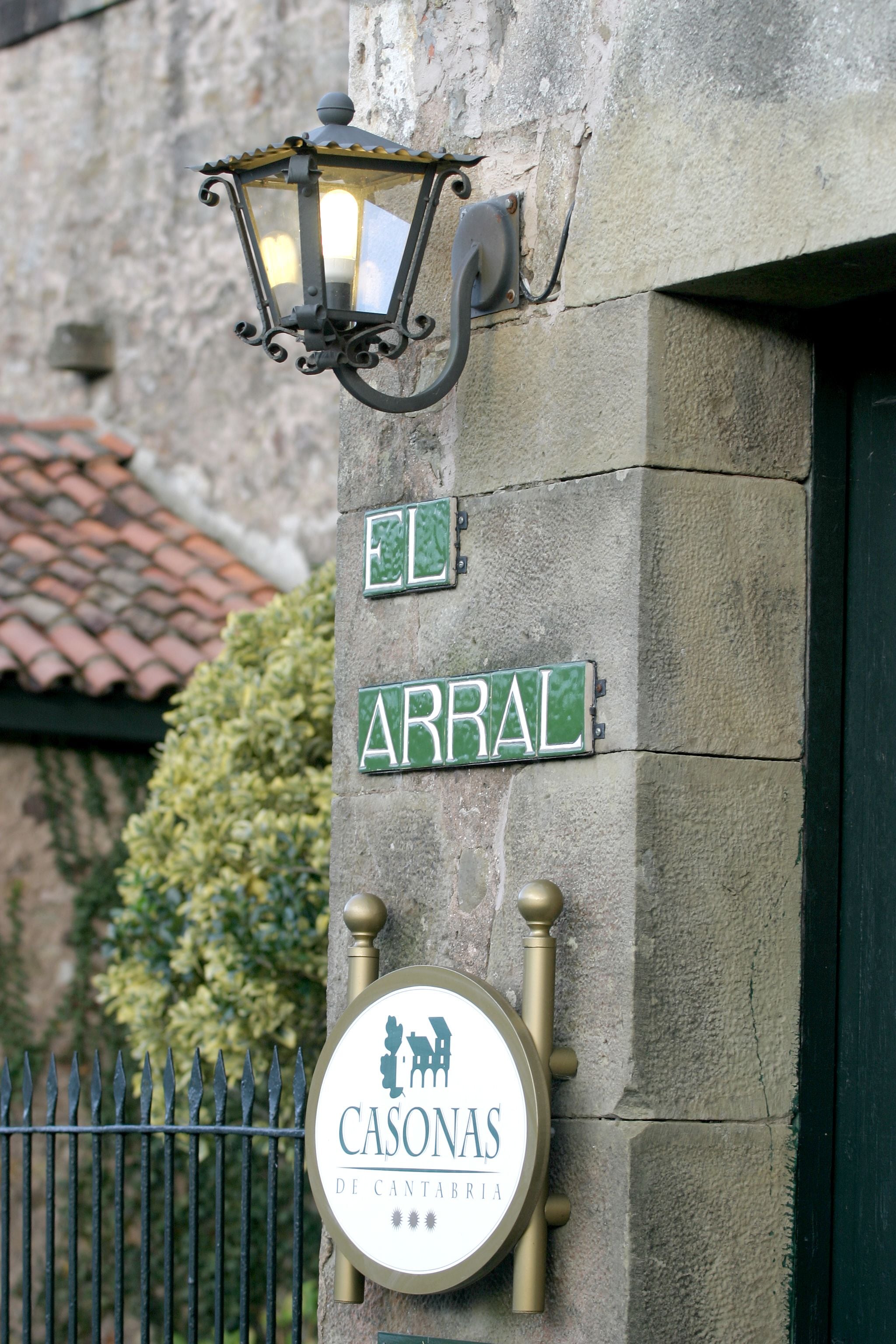 Uma placa de rua com 'ARRAL' e um poste de luz com 'CASONAS DE CANTABRIA'.