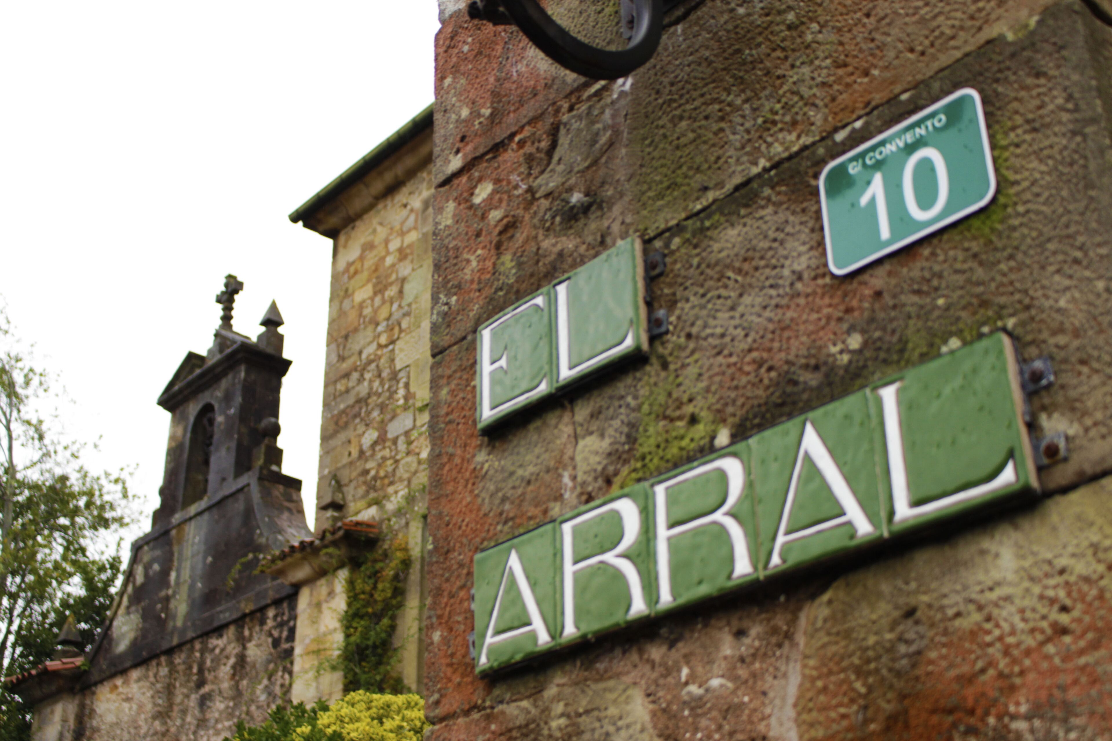 Señales de calle en un edificio, incluyendo 'EL ARRAL' y 'CONVENTO 10'.