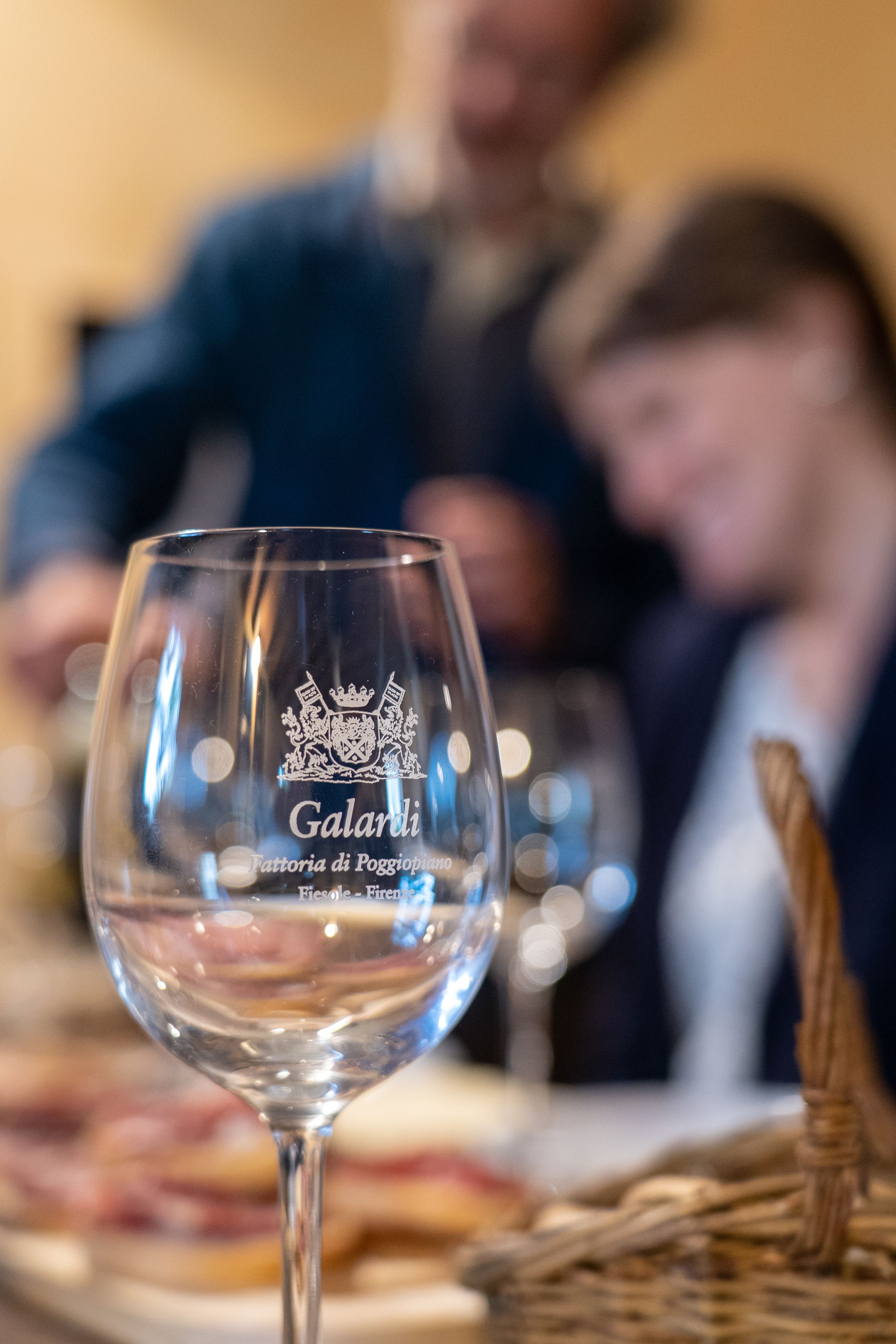 Un got de vi amb la inscripció "Galardi" i "Fattoria di Poggiopiano" sobre una taula.