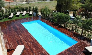 Piscine extérieure en saison, chaises longues