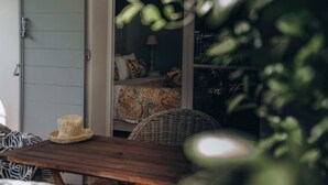 A room with a bed, a nightstand, a lamp, and a wicker chair. - La Villa d'Andrea (Ramatuelle)