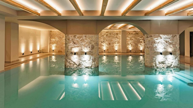 A spacious indoor swimming pool with stone walls and wooden beams. - Cook's Club Hersonissos Crete (Hersonissos)
