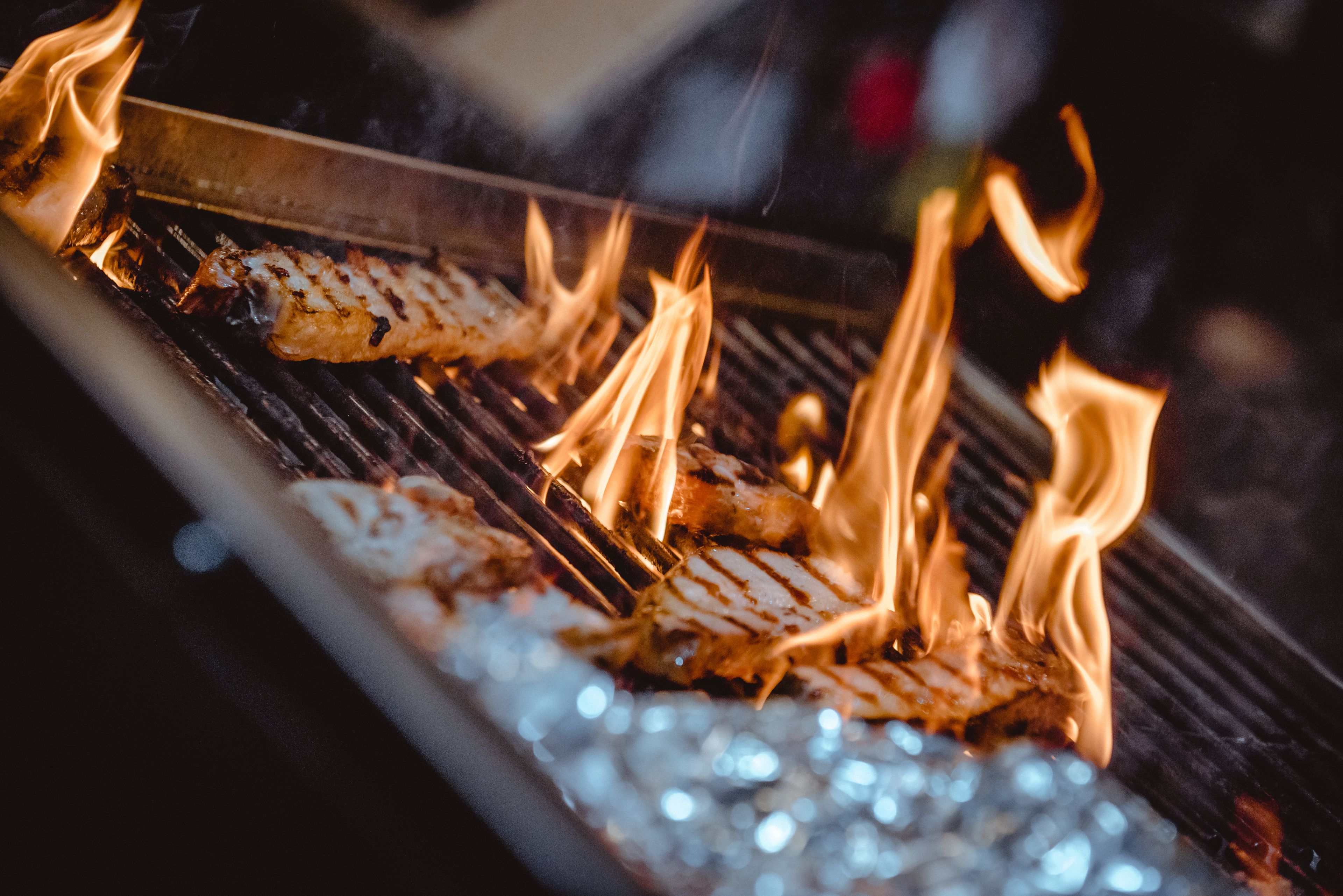 Una parrilla con comida cocinándose sobre llamas abiertas.