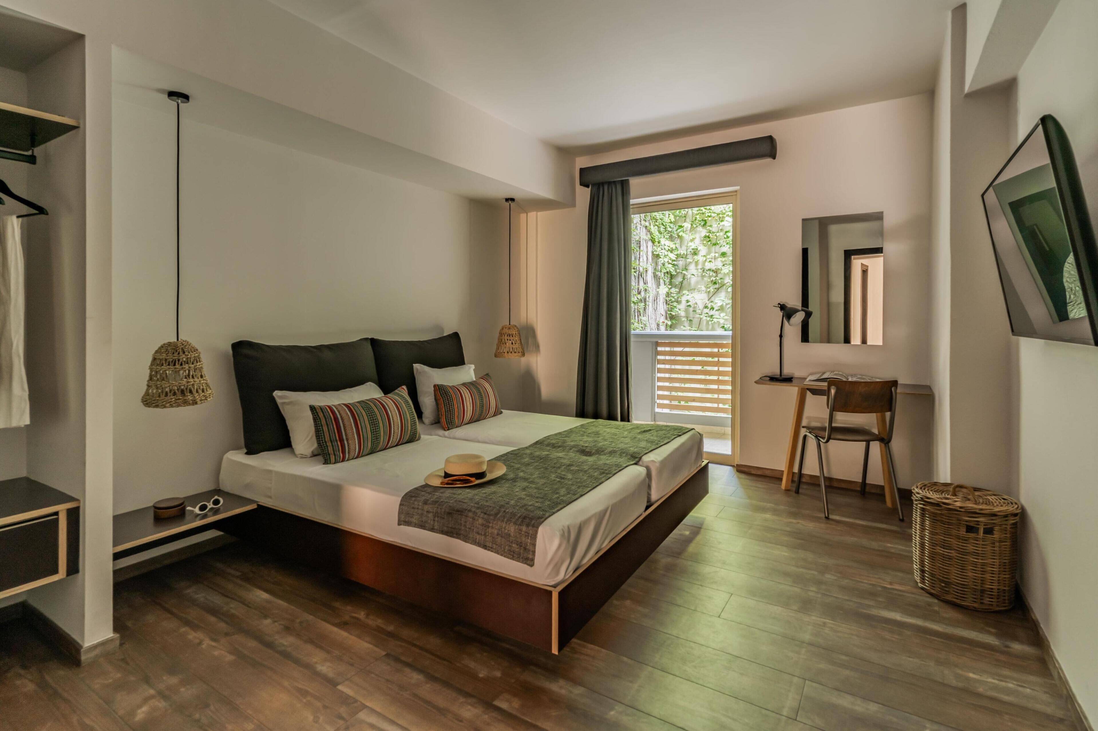 A modern bedroom with a large bed, bedside lamps, a desk, and a chair.