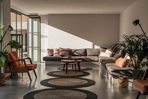 A modern living room with a sofa, armchairs, and a coffee table.