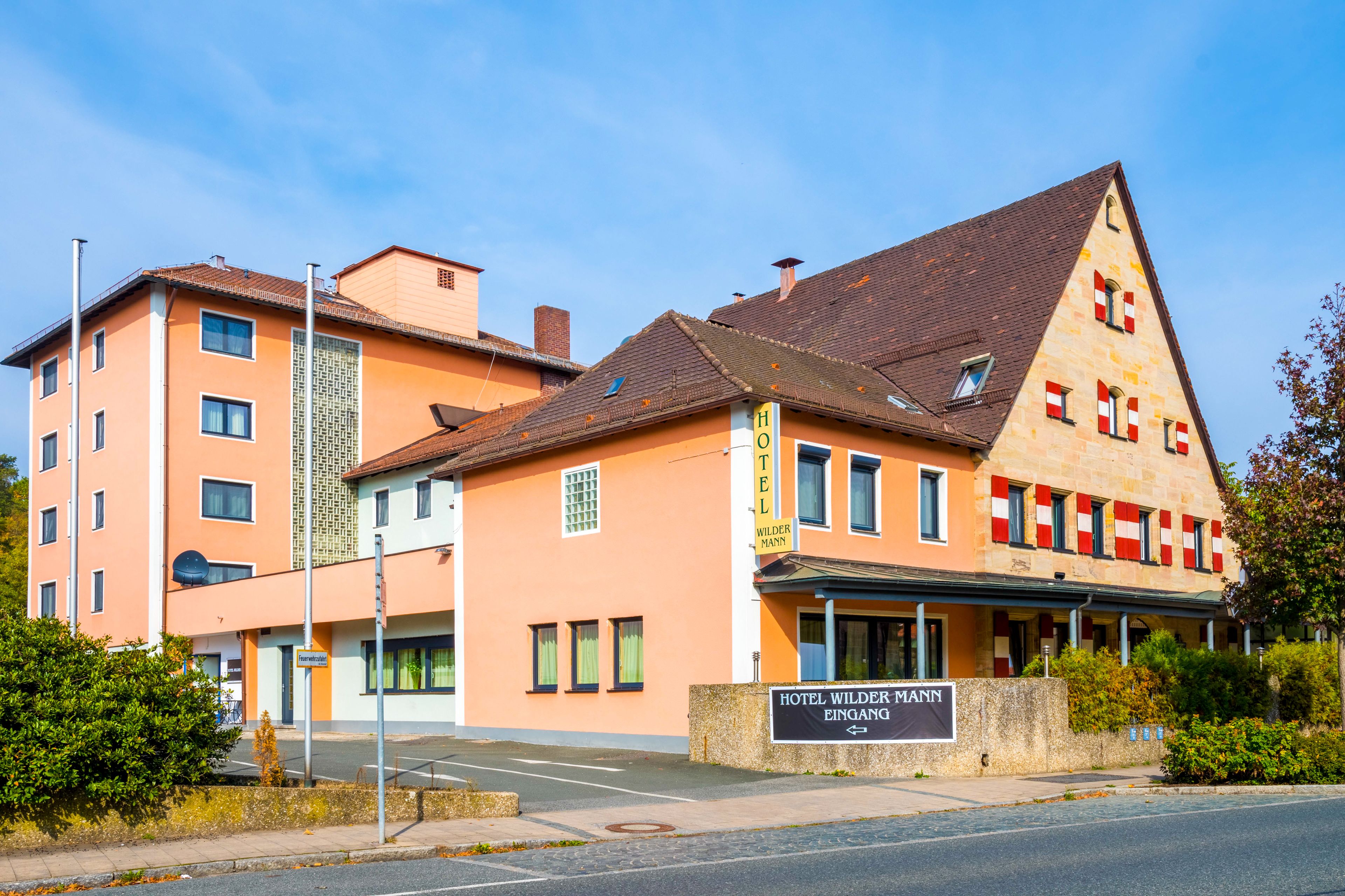 Un hotel con un cartello che recita 'HOTEL WILDER MANN EINGANG'.