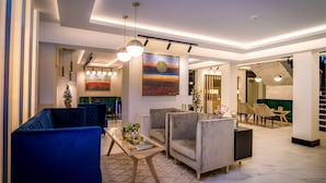 A modern living room with sofas, a coffee table, and pendant lighting.