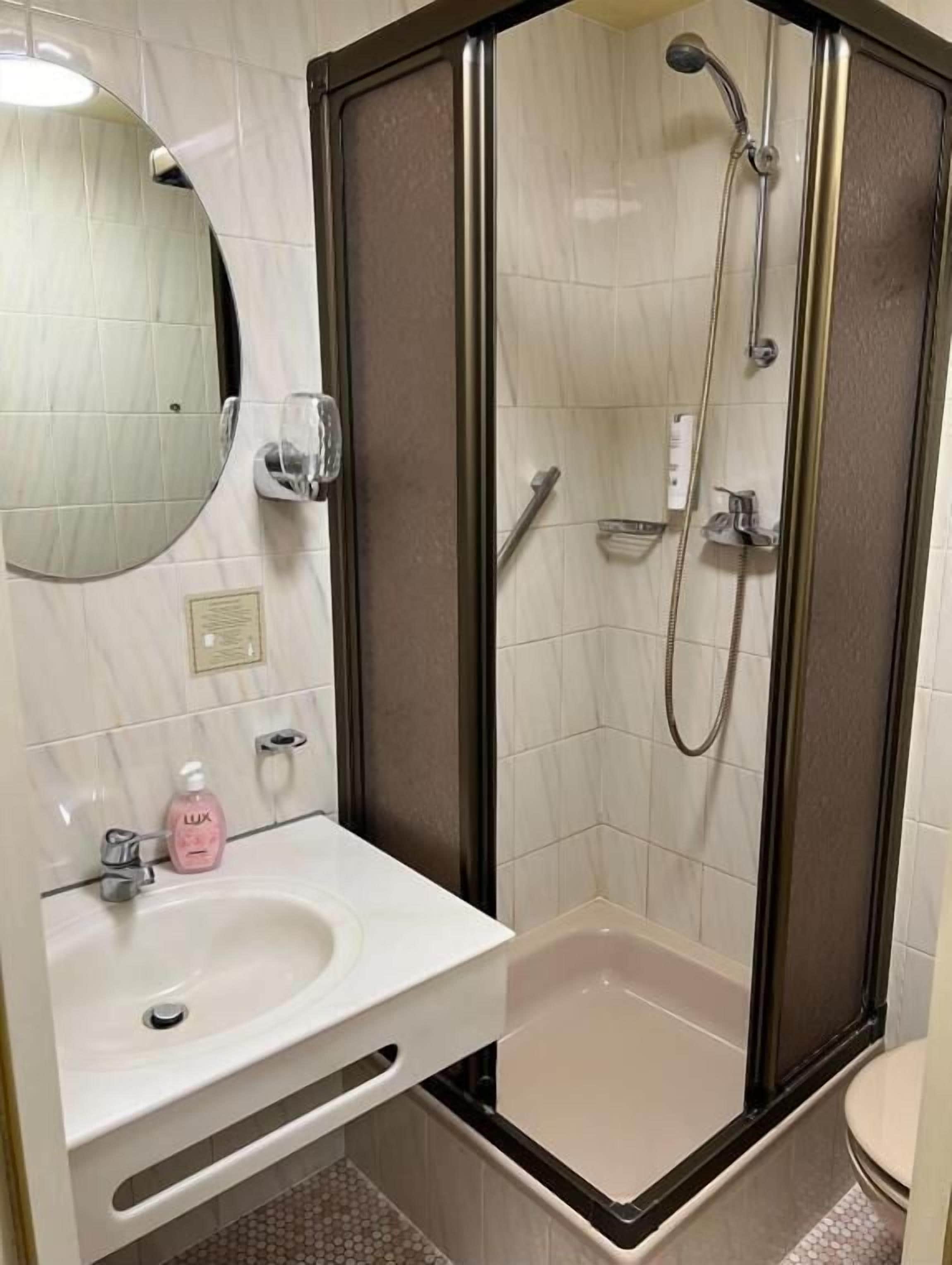 Un baño con ducha, lavabo e inodoro.