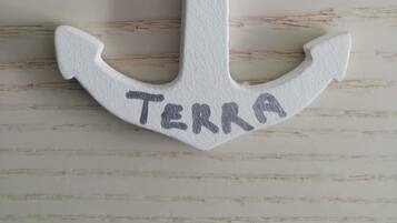 Eine weiße, ankerförmige Dekoration mit dem Wort "TERRA".