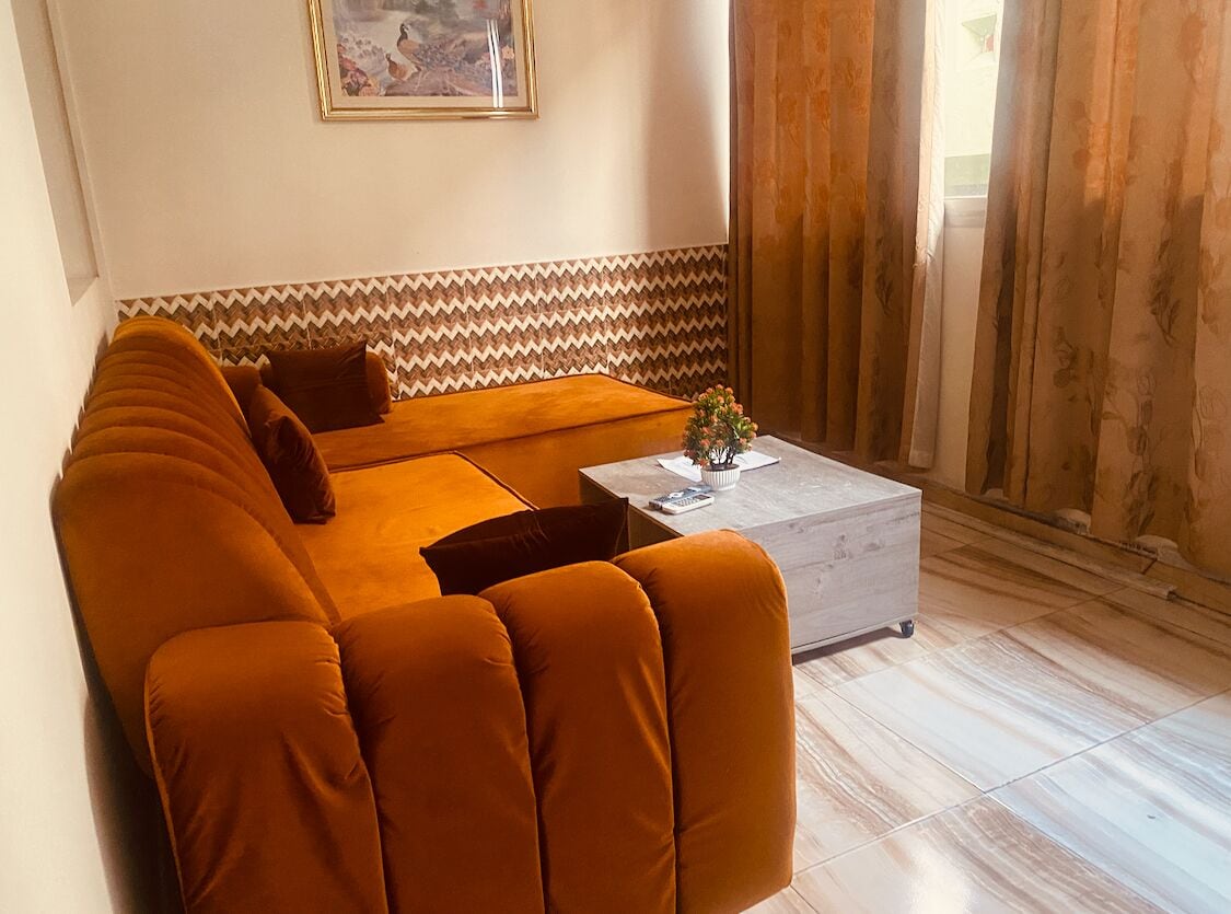 A living room with a sofa, a coffee table, and a patterned wall.
