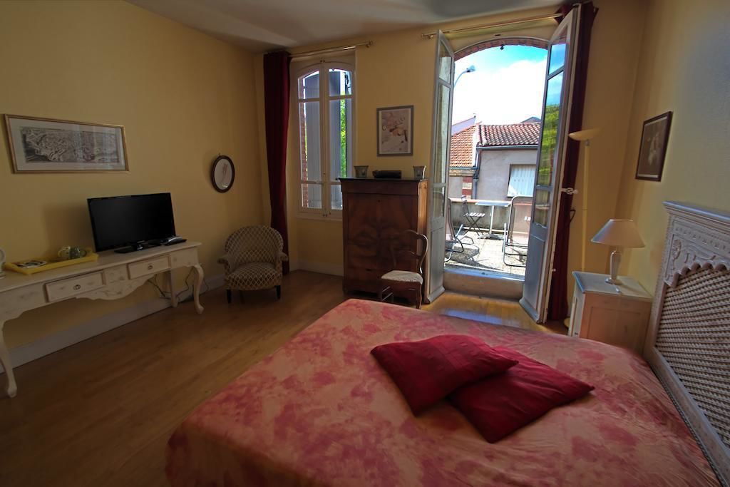Une chambre à coucher avec un lit, un bureau, une chaise, une télévision et une fenêtre.