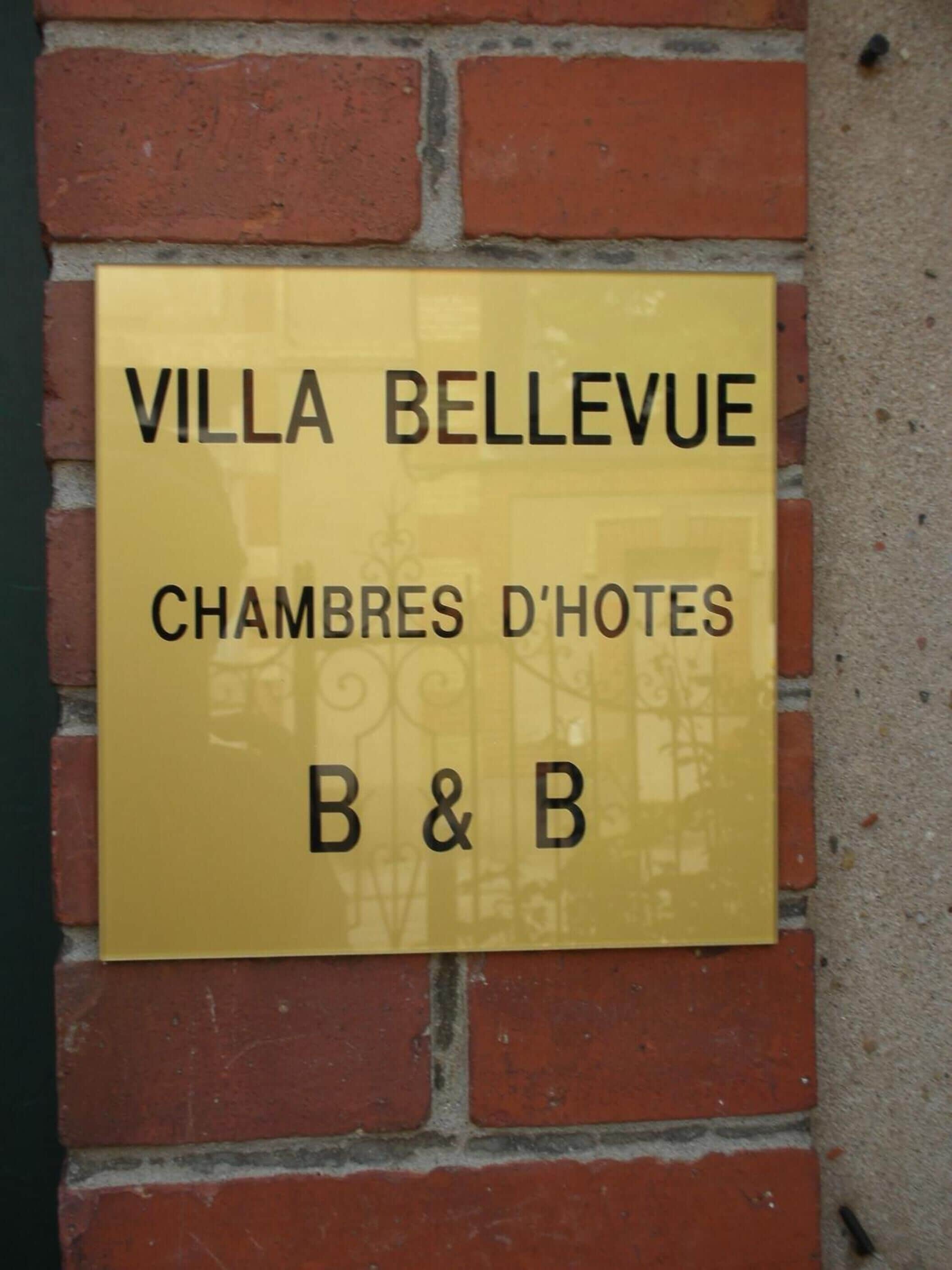 A sign for Villa Bellevue, indicating it is a hotel with rooms for rent.