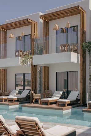 A modern hotel with a pool area featuring sun loungers and wooden deck chairs. - Galazio Beach Resort (Hersonissos)