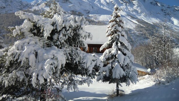 A snow-covered mountain landscape with a wooden cabin in the foreground. - Auberge Du Pont De L'Alp (Monetier-les-Bains)